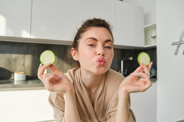 Portrait of beautiful brunette girl cooking in the kitchen posing in bathrobe at home holding