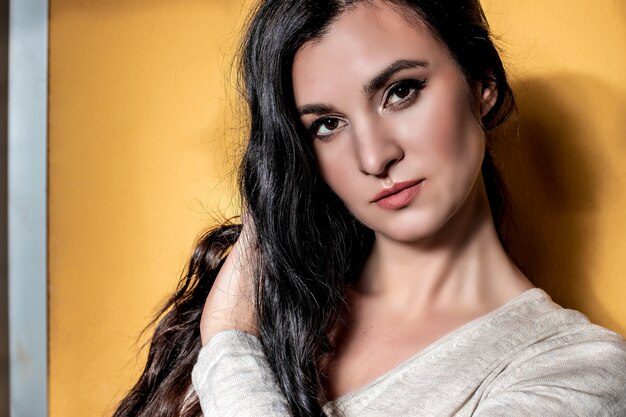 Portrait of a beautiful brunette girl with long curly hair