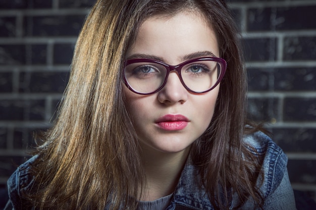 Portrait of beautiful brunette teen girl, wearing glasses