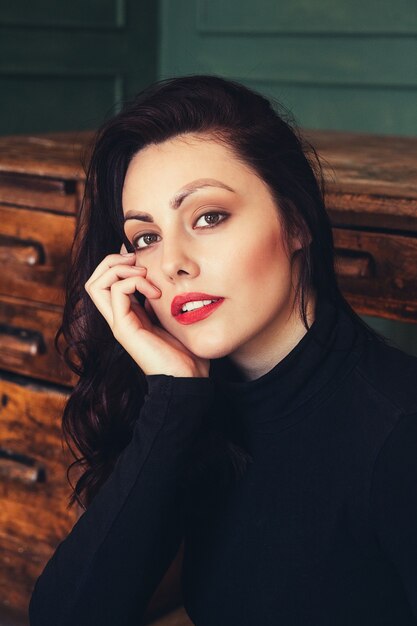 Portrait of a beautiful brunette woman on the background of a wooden table