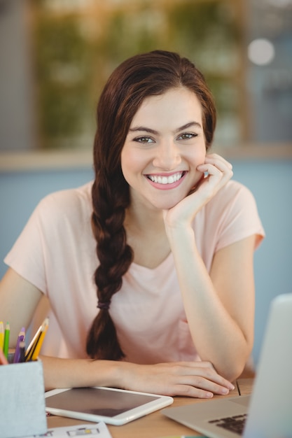 Portrait of beautiful business executive sitting at desk