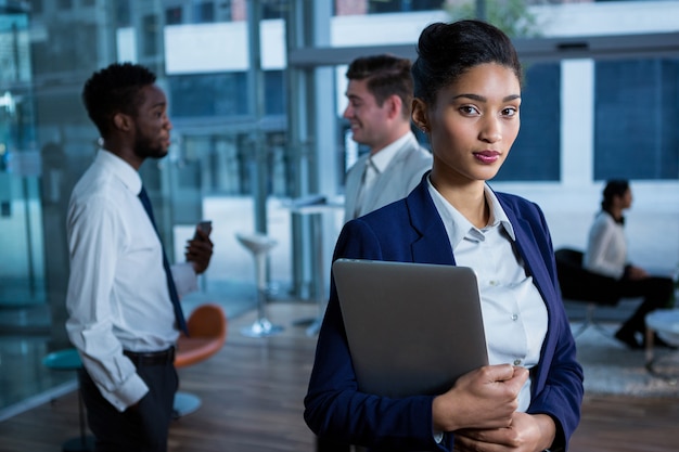 Portrait of beautiful businesswoman holding laptop