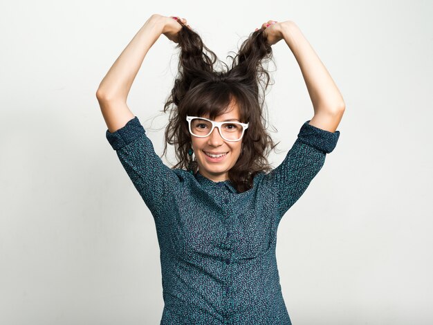 Photo portrait of beautiful businesswoman with eyeglasses against white wall