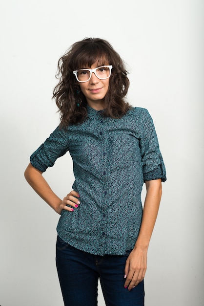 Portrait of beautiful businesswoman with eyeglasses against white wall