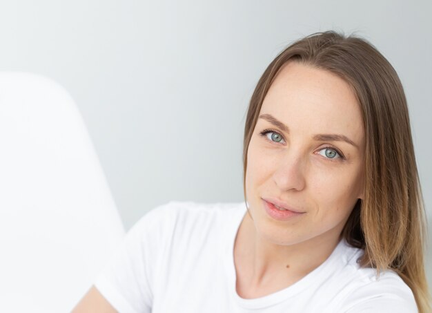 Portrait of a beautiful caucasian young woman posing against white wall background. The concept of a beautiful well-groomed woman. Copyspace