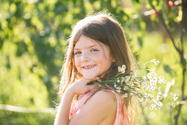 Portrait of beautiful child girl in the summer blossoming garden happy kid on the meadow with white