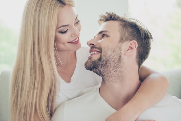 Portrait of beautiful couple in casual white tshirts looking at each other home