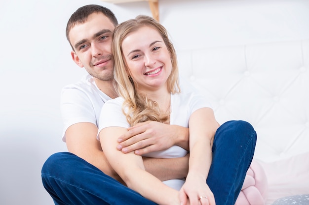 ジーンズの美しいカップルの肖像画。若い男と女を抱いて。恋人