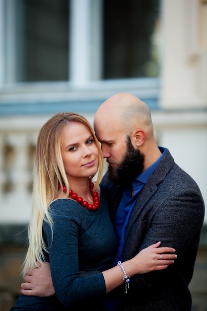 Portrait of a beautiful couple walking on the street in the summer, it has a stylish jacket, she dressed in a dress