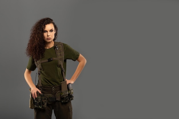 Портрет красивой кудрявой брюнетки с серьезным выражением лица женщины-солдата