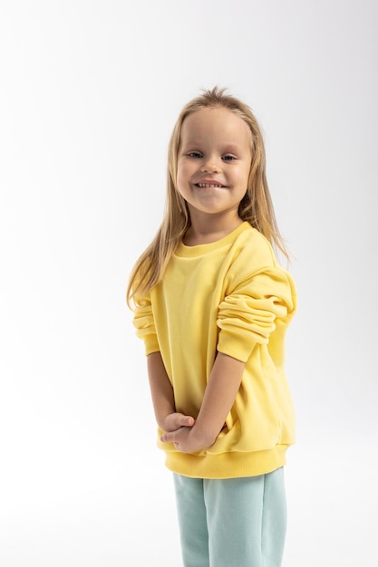Портрет красивой милой маленькой девочки с смешным лицом в желтой рубашке