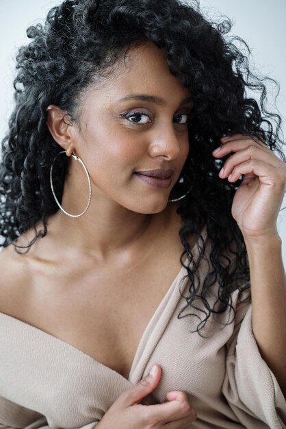 Photo portrait of a beautiful dark skin woman with long curly hair smiling