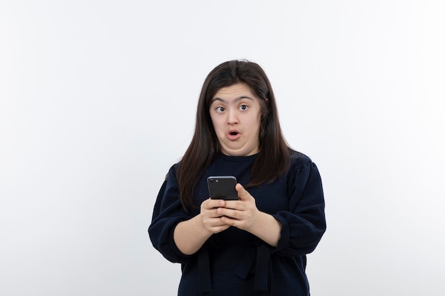 Portrait of beautiful down syndrome girl holding cellphone.