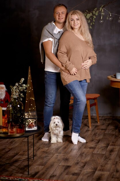 아름다운 가족의 초상화 크리스마스 트리 근처에 개와 함께 있는 낭만적인 커플의 초상화 크리스마스 러브 스토리의 좋은 분위기 솔직한 진정한 순간