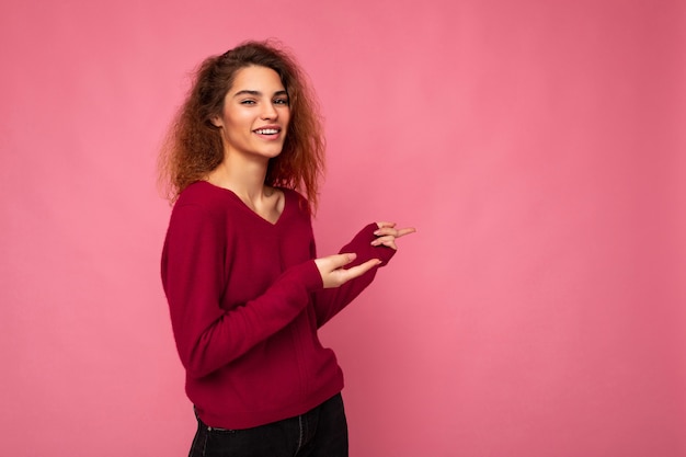 Portrait of beautiful fascinating emotional positive joyful happpy female promoter pointing to the