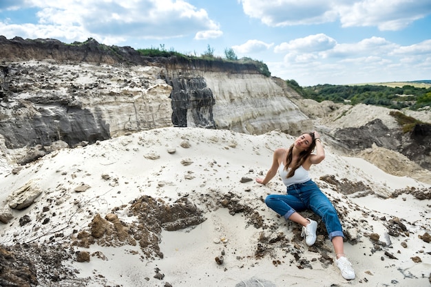 砂漠への美しいファッション女性旅行者の肖像画、砂の上でリラックス、暑い夏の日