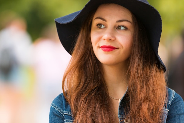 Portrait of the beautiful fashionable girl with hat outdoor on summer day