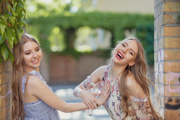 Photo portrait of beautiful friends standing at doorway in park