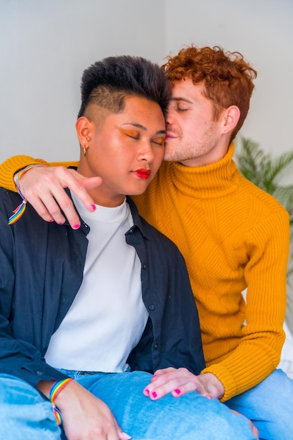 Photo portrait of beautiful gay couple making up and kissing smiling indoors at home lgbt concept