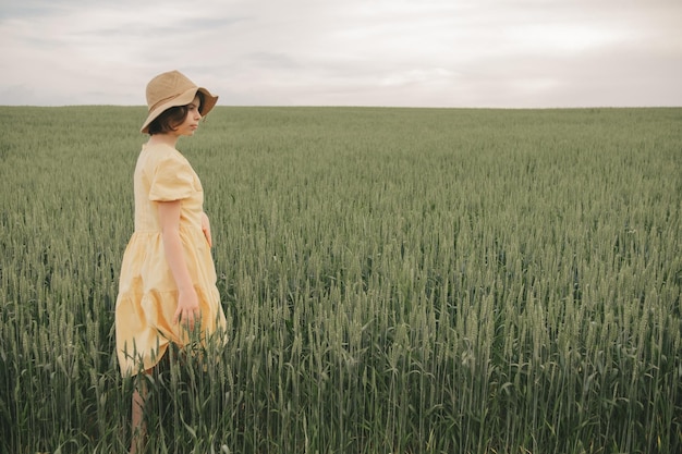 portrait of a beautiful girl 10-13 in a yellow dress in a field