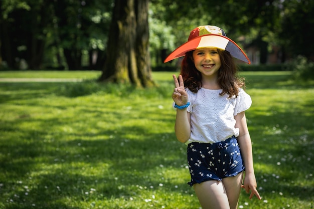 公園でベルギー国旗の帽子をかぶった美しい女の子の肖像画