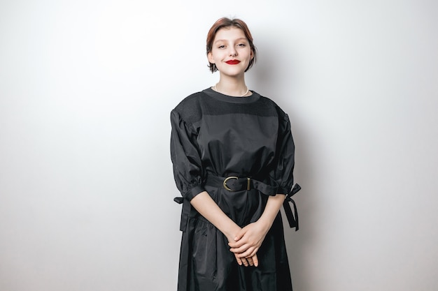 Portrait of a beautiful girl in a black dress, looking at the camera