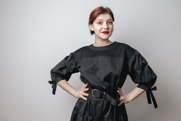 Portrait of a beautiful girl in a black dress, looking at the camera