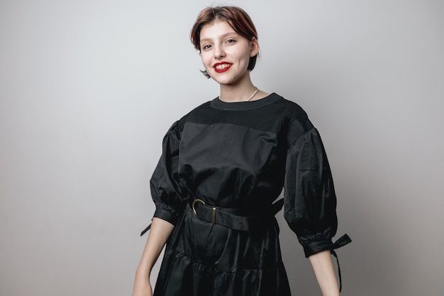 Portrait of a beautiful girl in a black dress, looking at the camera