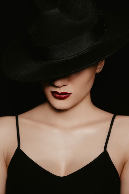 Portrait of a beautiful girl in a black hat and dress