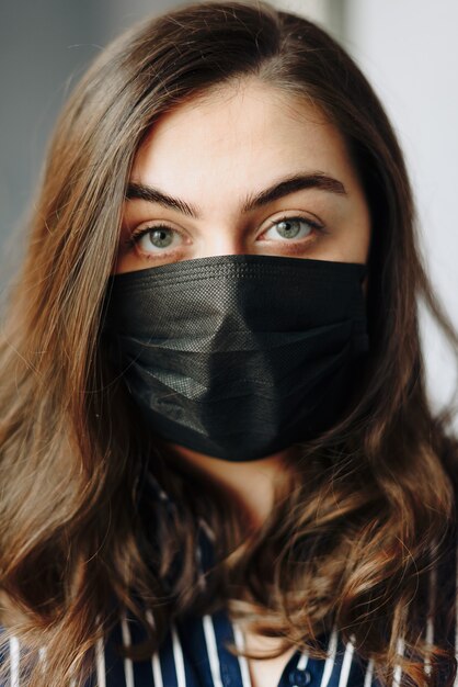 Portrait of a beautiful girl in a black protective mask