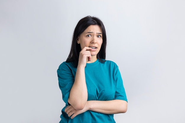 Portrait of a beautiful girl  in a blue tshirt looks aside with pensive expression