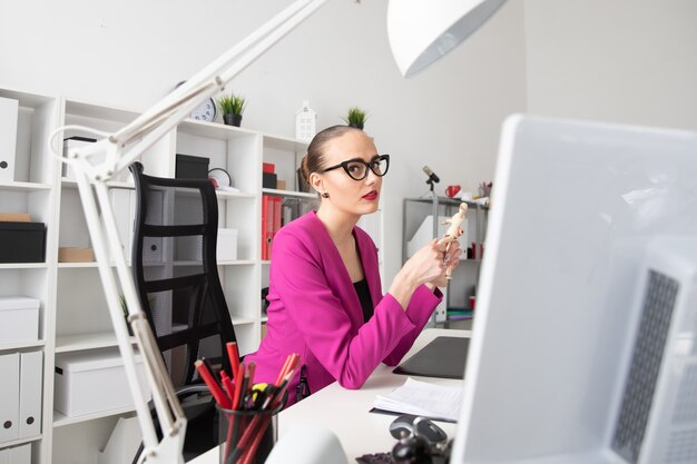 Portrait of a beautiful girl in business style sitting at a desk in the office