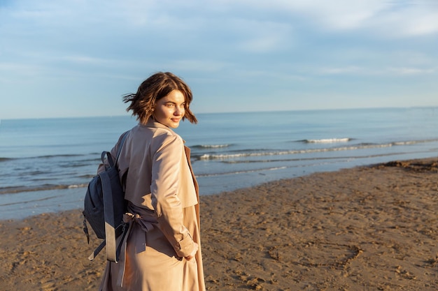 Ritratto di una bella ragazza in un cappotto in riva al mare. italia.