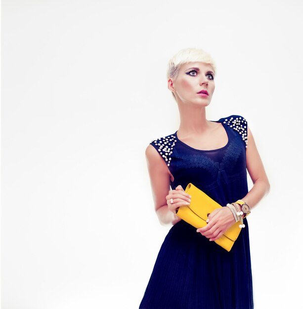 Portrait of a beautiful girl in evening dress with a clutch