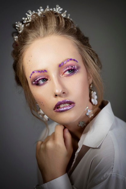 Ritratto di una bella ragazza volto del modello con il trucco viola trucco beautywinter