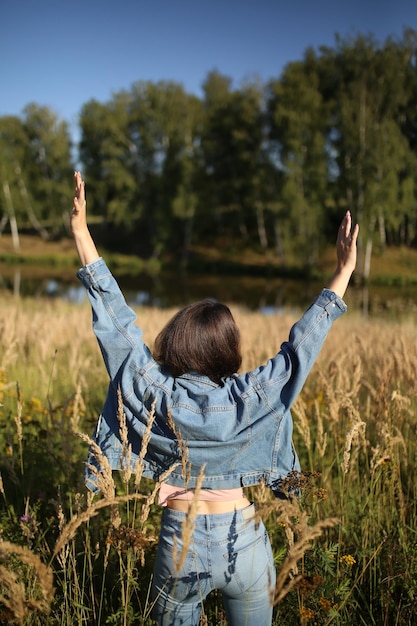 Foto ritratto di una bella ragazza di spalle che guarda verso la natura