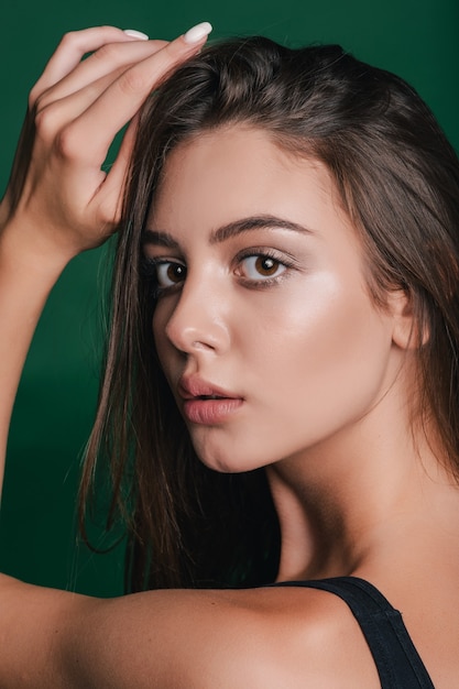 Portrait of a beautiful girl on green background.