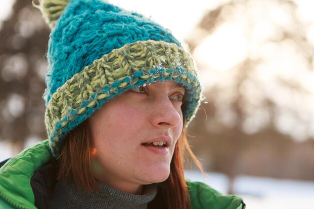 Ritratto di una bella ragazza con cappello e sciarpa sullo sfondo nella stagione fredda. ragazza che cammina per strada