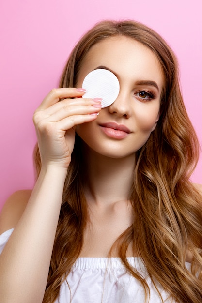 Portrait of a beautiful girl holding a cotton pad