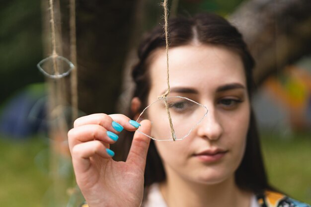 Ritratto di una bella ragazza che tiene un occhio di vetro appeso a un filo