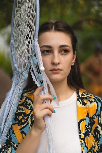 Portrait of a beautiful girl holding a glass eye hanging by a thread