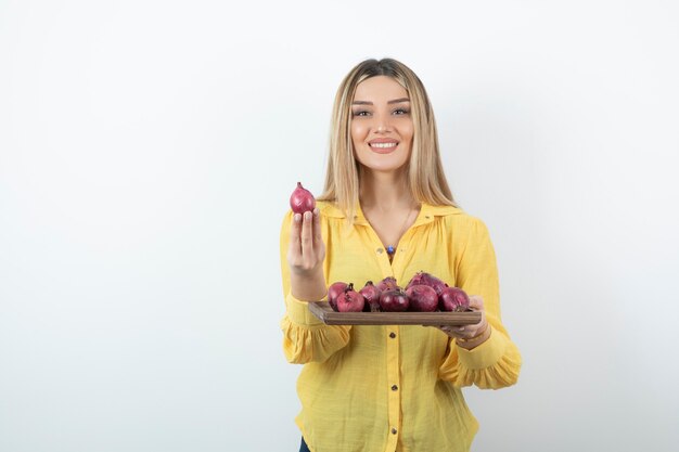 Portrait of beautiful girl holding red onions and standing