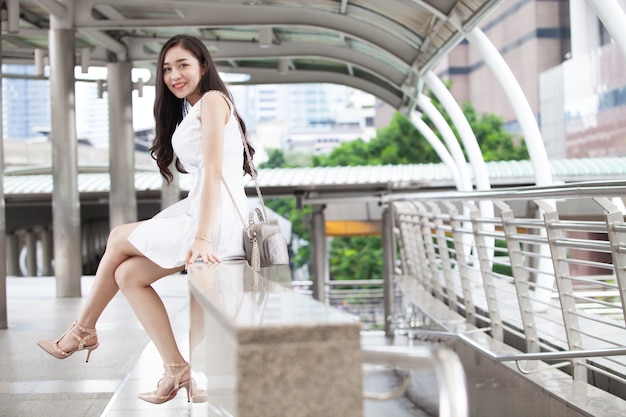 Portrait of beautiful girl holding shopping bags and smiling while waliking the street