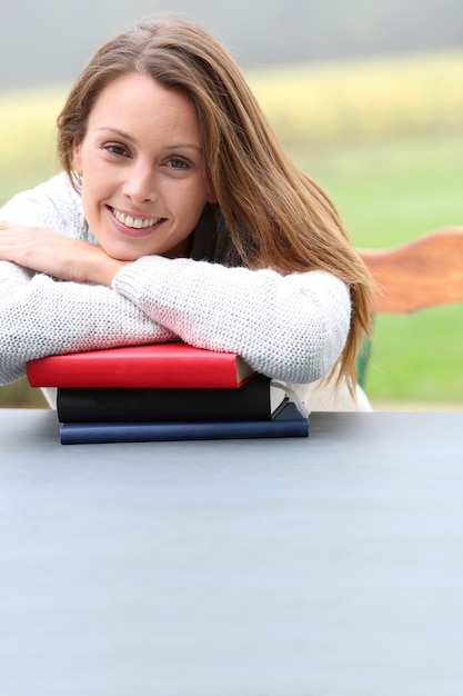 Photo portrait of beautiful girl leaning on books