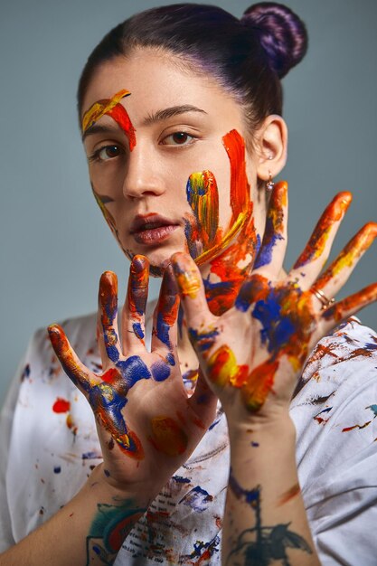 Foto ritratto di una bella ragazza in pittura ritratto in primo piano di una ragazza con il viso e le mani con