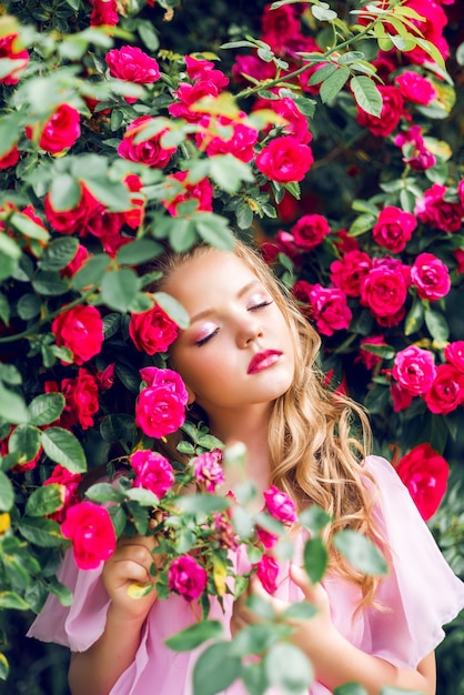 Foto ritratto di una bella ragazza in fiori di rosa