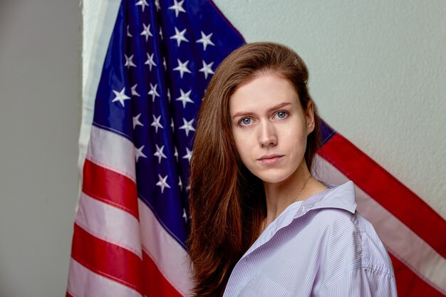 Portrait of beautiful girl in shirt on american flag background close up