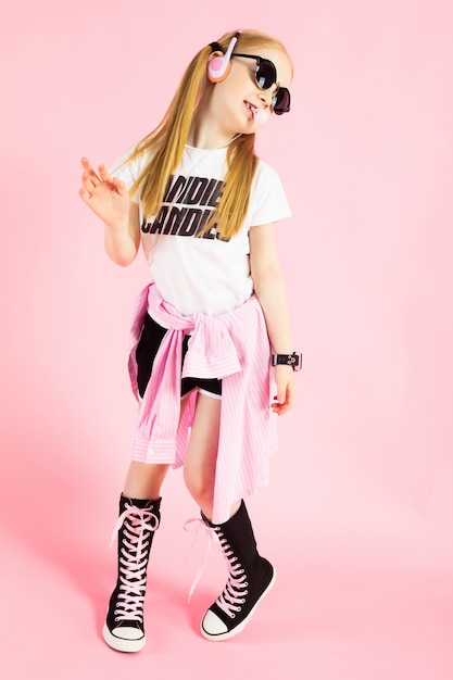 Portrait of a beautiful girl in shorts, a T shirt and high sneakers.