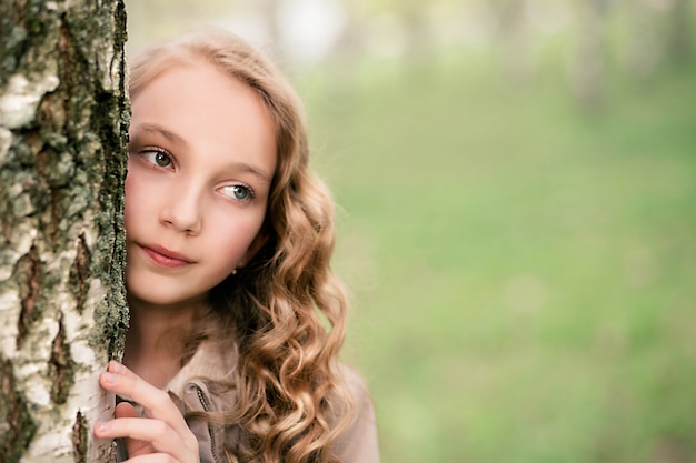 Портрет красивой девушки, стоя рядом с деревом