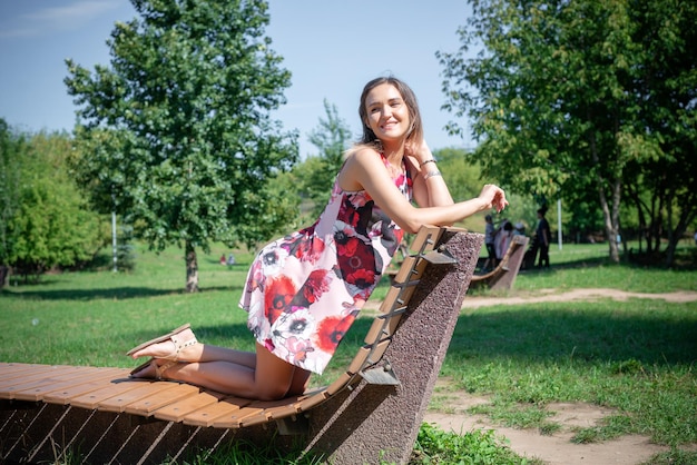 Portrait of a beautiful girl in the summer on a chaise longue